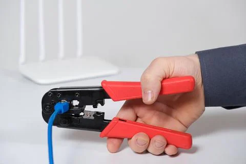 The computer master crimps the connection of the Vlan connector with a special Stock Photos