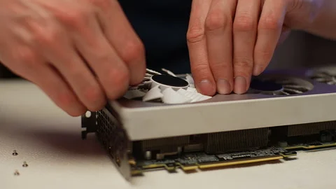 Computer master dismantling modern gaming video card, taking off cooler blades Stock Footage 271298673