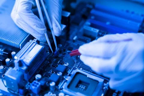 Computer master in gloves working with tweezers on   cpu board Stock Photos