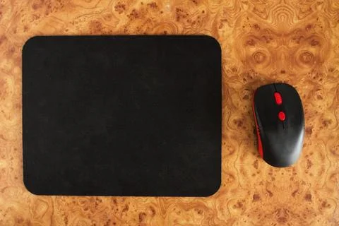 Computer mat and computer mouse on a brown patterned background, close-up Foto stock