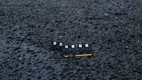 Computer memory RAM chips lying on wet asphalt during rainfall Stock Footage 338327303