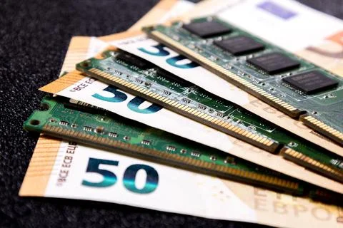 Computer memory sits on top of fifty euro bills showing the connection between Stock Photos