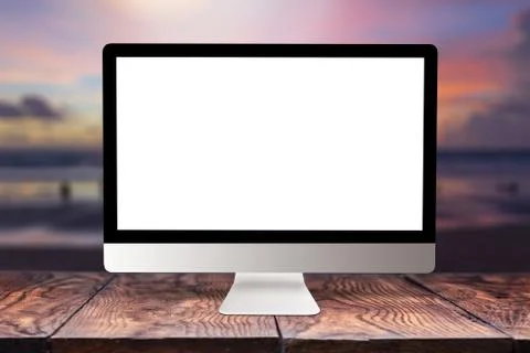 Computer mockup screen on wooden table against sea background. Stock Photos