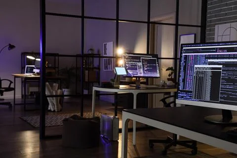 Computer monitor with code on programmer's desk in dark office 스톡 사진