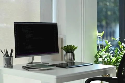 Computer monitors with coded data, supplies on wooden table in software Foto stock