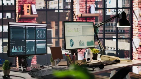 Computer monitors on office desk showing data analytics dashboards Stock Footage 305401699