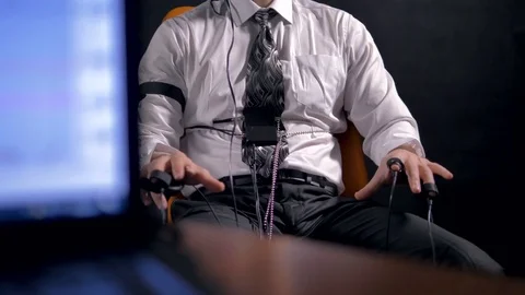 A computer monitors  polygraph data beside a sitting man. Stock Footage 78291609