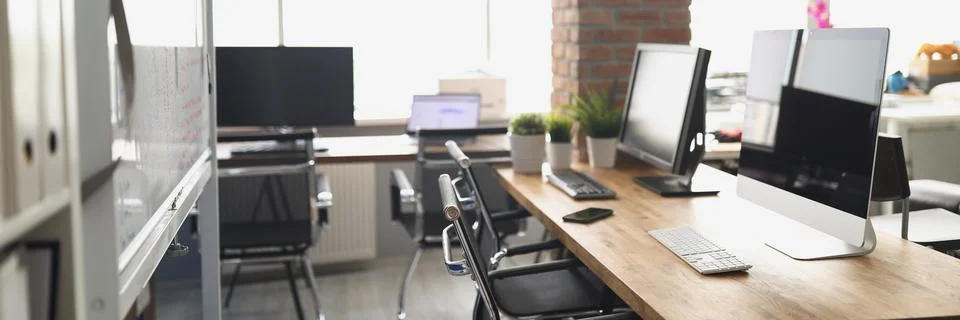 Computer monitors standing on table in empty office Stock Photos