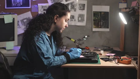 Computer motherboard diagnostics. Female programmer inspecting circuit and note Stock Footage 236318407