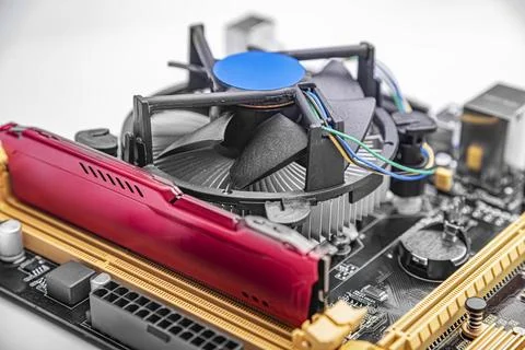 A computer motherboard featuring a memory module and a cooling fan on a white Stock Photos