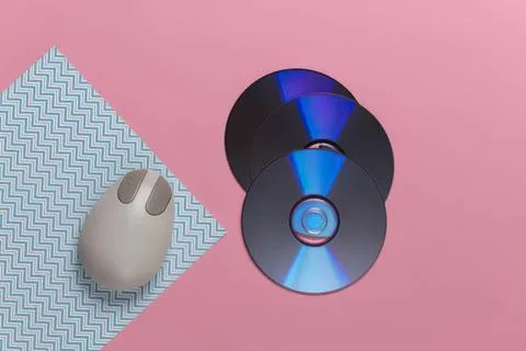 Computer mouse and cds on pink background Stock Photos