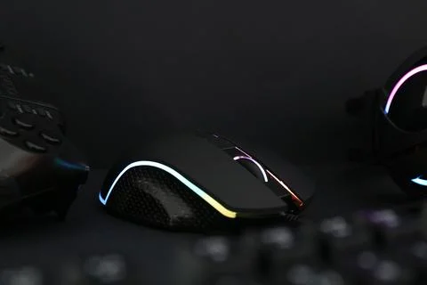Computer mouse and game controller on dark background, closeup Stock Photos