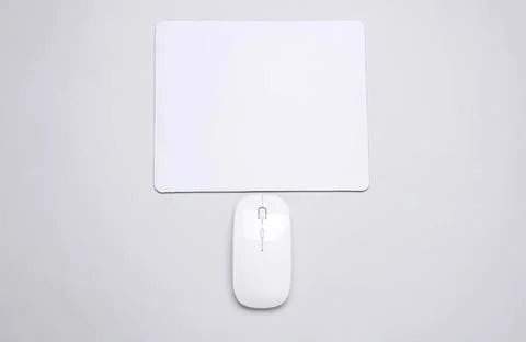 Computer mouse and mouse pad on light gray desk surface Stock Photos