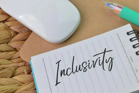 Computer mouse and notebook written with text INCLUSIVITY Foto stock