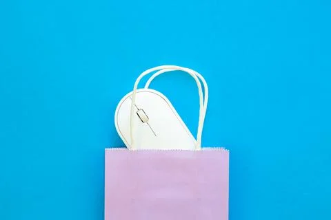 Computer mouse and paper bag on a blue background, top view. Stock Photos