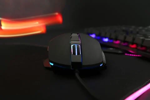 Computer mouse and RGB keyboard on dark background, closeup Stock Photos