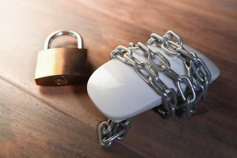 Computer mouse with chain and padlock on wood background, security concept Stock Photos
