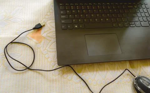 Computer mouse connection cable plugin placed in front of the laptop keyboard Stock Photos