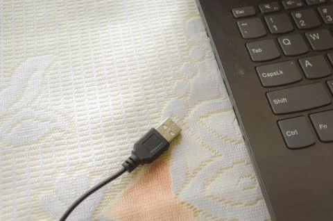Computer mouse connection cable plugin placed in front of the laptop keyboard Stock Photos