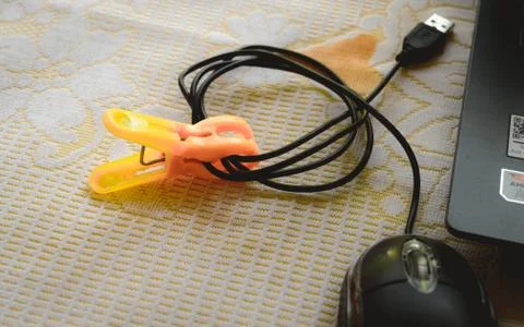 Computer mouse connection plug-in rolled and clipped and placed in front of t Stock Photos