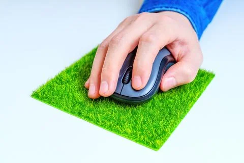 Computer Mouse in Hand on a Grass Mousepad Stock Photos