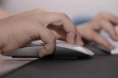 Computer mouse in the hands of a child. Stock Photos