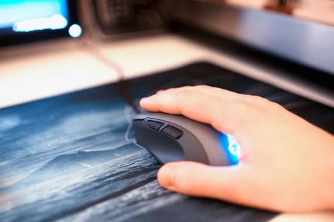 Computer mouse with human hand on mousepad bokeh backdrop Stock Photos