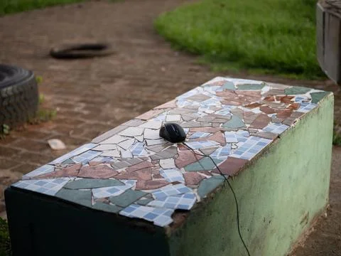Computer mouse on mosaic bench in outdoor park Foto stock