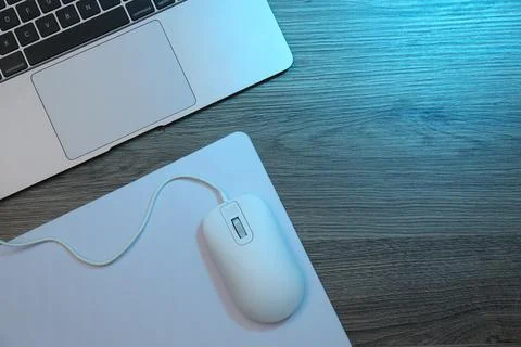Computer mouse with mousepad and laptop on wooden table, flat lay. Space fo.. Stock Photos