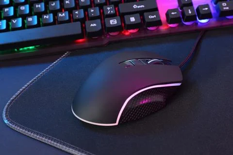 Computer mouse, mousepad and RGB keyboard on dark background, closeup Foto stock