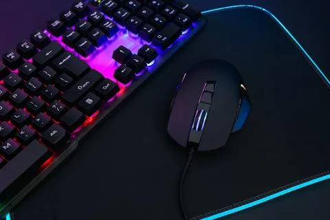 Computer mouse, mousepad and RGB keyboard on dark background, closeup Foto stock