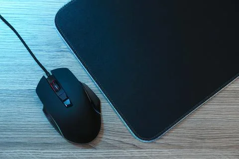 Computer mouse with mousepad on wooden table, flat lay Stock Photos