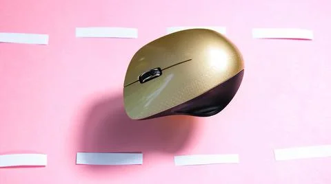 The computer mouse moves on a pink background, as if on a road. Stock Photos