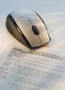 Computer mouse next to tax form Stock Photos