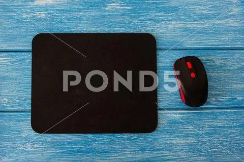 Computer mouse pad and mouse on a blue wooden background Stock Photos