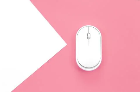 Computer mouse on a pink background close-up, top view. Stock Photos