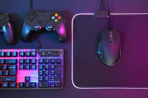 Computer mouse, RGB keyboard and game controllers in neon lights on dark ba.. Foto stock