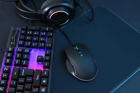 Computer mouse, RGB keyboard and headset on black background Foto stock