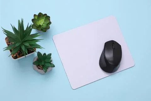 Computer mouse on a white mouse pad with green succulents Stockfoto's