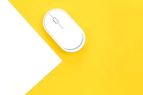 Computer mouse on a yellow background close-up, top view. Stock Photos