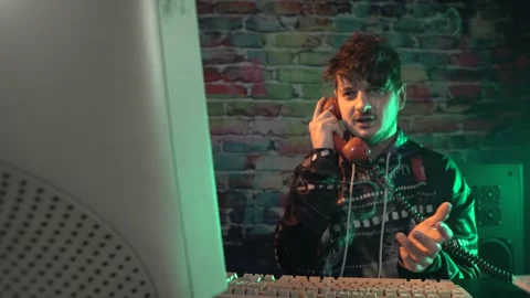 Computer Nerd From 1980s Talking Over Landline Telephone in Front of Monitor Stock Footage 297952049