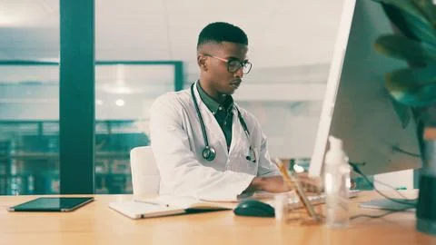 Computer, notebook and typing with doctor black man at hospital desk for re.. 스톡 사진