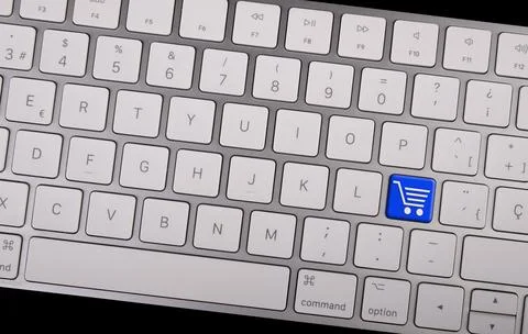 Computer notebook keyboard with icon shopping cart on key. E-commerce concept Fotos Stock