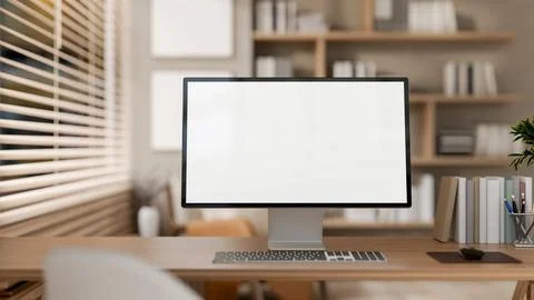 A computer placed on a wooden desk by the window in a cozy Scandinavia room. Illustrazione stock