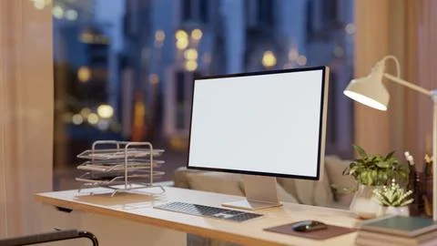 A computer placed on a wooden table in a modern living room, illuminated by.. Ilustración de archivo