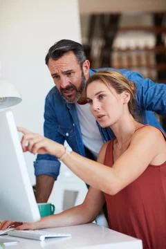 Computer, pointing and talking with couple in home together for debt review or Stock Photos