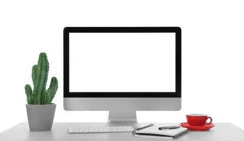 Computer, potted cactus and notebook on table against white background. Sty.. Stock Photos