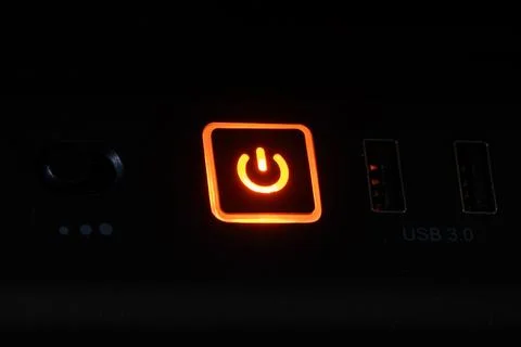 Computer power button glowing in the dark Stock Photos