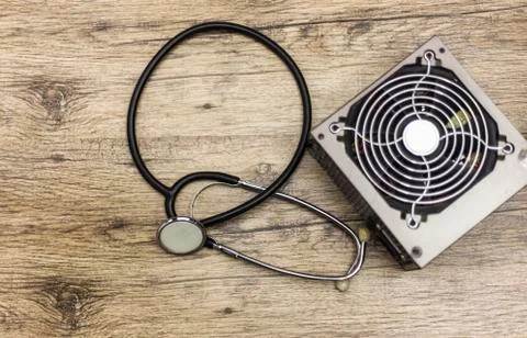 Computer power suply representing a phonendoscope health and wellness on wood Stock Photos