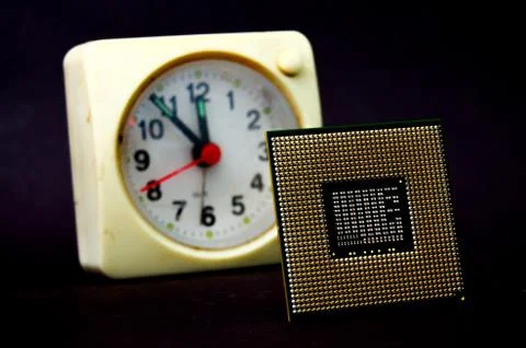 The computer processor on a dark background and vintage clock 写真素材